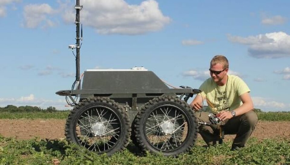Karl Damkjær Hansen is making adjustments to one of the field robots. Under the lid is a laptop, which serves as the robot’s ‘brain’. (Photo: ASETA project)