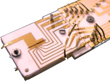 The ion trap used in the experiment. Electrical potential is applied through thin gold wires on a chip and used to trap ions in a narrow slot. (Credit NIST). The ion trap used in the experiment. Electrical potential is applied through thin gold wires on a chip and used to trap ions in a narrow slot. (Credit NIST).