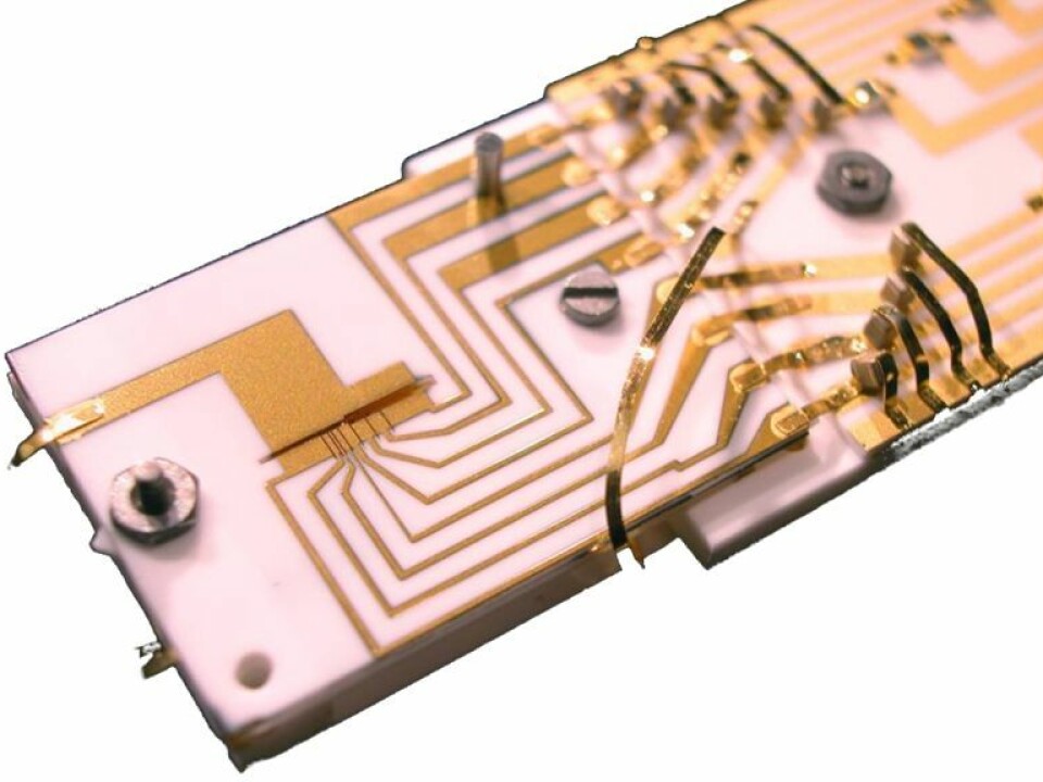 The ion trap used in the experiment. Electrical potential is applied through thin gold wires on a chip and used to trap ions in a narrow slot. (Credit NIST).
