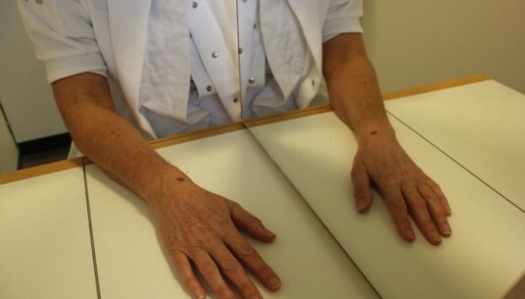 An occupational therapist demonstrates the principle of mirror therapy: the mirror is positioned so that the existing arm is reflected in the mirror. Here, some patients will find that their phantom arm merges with the arm they see in the mirror, and this can relieve the phantom pains. In a new study, researcher Bo Geng aims to further develop this form of treatment, while at the same time stimulating the stump of the amputated limb with tiny electrical shocks. (Photo: Lise Brix) An occupational therapist demonstrates the principle of mirror therapy: the mirror is positioned so that the existing arm is reflected in the mirror. Here, some patients will find that their phantom arm merges with the arm they see in the mirror, and this can relieve the phantom pains. In a new study, researcher Bo Geng aims to further develop this form of treatment, while at the same time stimulating the stump of the amputated limb with tiny electrical shocks. (Photo: Lise Brix)