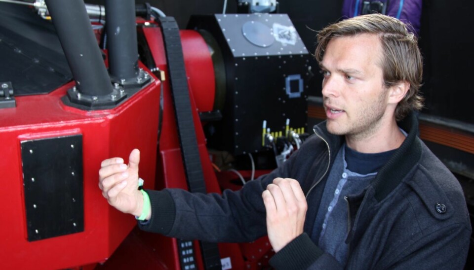 SONG astronomer Mads Fredslund Andersen has been responsible for developing a lot of the software for the telescope. Behind him is an advanced camera that will be used to locate planets. (Photo: Lise Brix)
