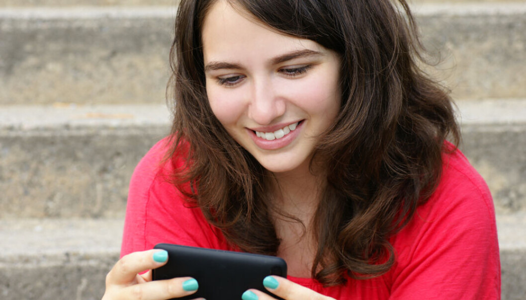 By analysing 3,800 Facebook comments, researchers at RUC have concluded that our discussions in the social media are simply too polite. This is probably because we are afraid of who might be reading in. (Photo: <a href=http://www.shutterstock.com/pic-110831846/stock-photo-young-woman-teenager-girl-or-student-reading-text-on-her-cell-phone-and-smiling-perfect-for.html?src=mY55hUfyDq5eXFjZR9jfyQ-1-122 target=”_blank”>Shutterstock</a>) By analysing 3,800 Facebook comments, researchers at RUC have concluded that our discussions in the social media are simply too polite. This is probably because we are afraid of who might be reading in. (Photo: <a href=http://www.shutterstock.com/pic-110831846/stock-photo-young-woman-teenager-girl-or-student-reading-text-on-her-cell-phone-and-smiling-perfect-for.html?src=mY55hUfyDq5eXFjZR9jfyQ-1-122 target=”_blank”>Shutterstock</a>)