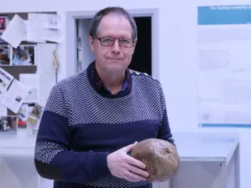 Jesper Lier Boldsen holding the skull of a man who lived with a skull fracture until it healed of its own. (Photo: Marianne Lie Becker, University of Southern Denmark)