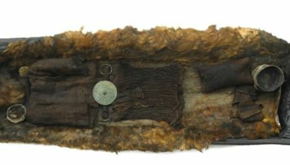 The Egtved Girl’s oak coffin shown along with a well-preserved wool garment and a bronze belt decorated with small spirals. (Photo: Roberto Fortuna, National Museum of Denmark)