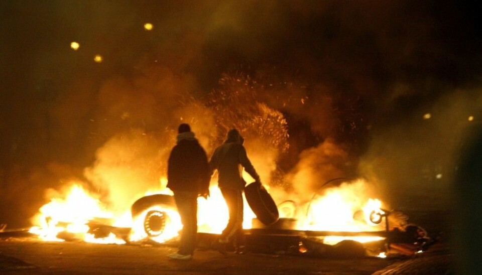 Youth throwing tyres onto the flames of a blockade they made in the Rosengård district of Malmö, Sweden. The city district has often been the site of clashes between youth and the police. (Photo: Drago Prvulovic / SCANPIX)