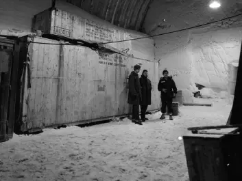 Danish and American Scouts Søren Gregersen and Kent Goering overwintered in the Camp in 1960, stand in front of a part of the nuclear reactor, packed away in boxes. (Photo: US Army)