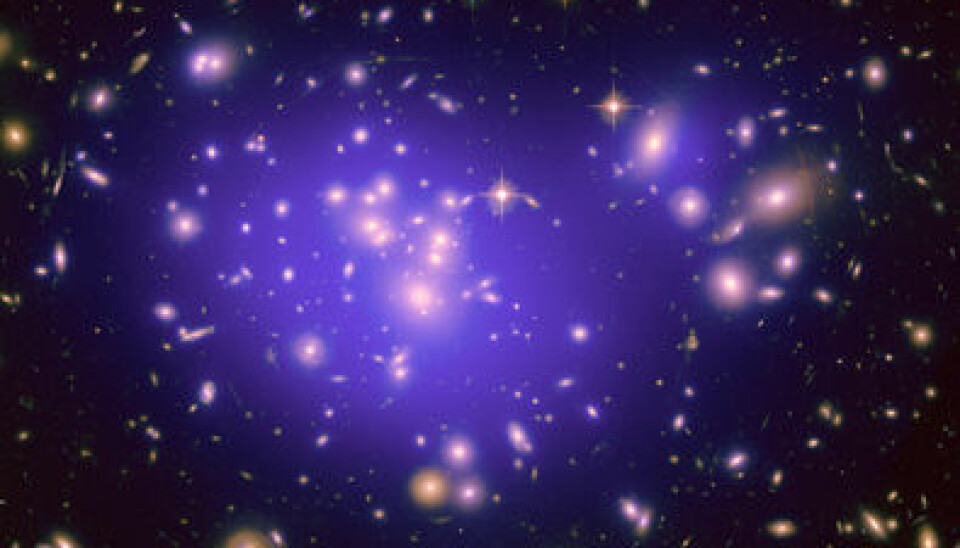 The light from the centre of distant galaxy clusters undergoes a gravitational red-shift as it travels through the cluster. The size of the red-shift is in perfect accordance with Einstein’s general theory of relativity. (Photo: NASA, ESA, E. Jullo (Jet Propulsion Laboratory), P. Natarajan (Yale University), and J.-P. Kneib (Laboratoire d'Astrophysique de Marseille, CNRS, France))