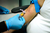 Blodprøvetaking med blå hansker ved en kvinneklinikk.