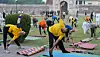 Participants perform yoga exercises on mats in a park in Lahore during International Yoga Day.